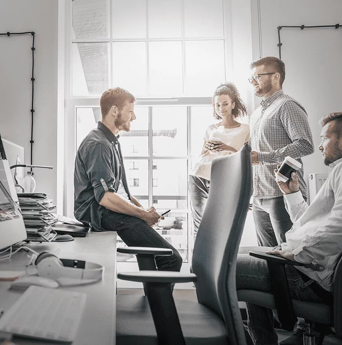 Team members talk casually in the office